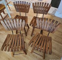 Four vintage MCM bentwood slat chairs arranged in a circle showing their seats and backs.