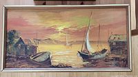 Front view of framed oil on canvas showing sailboats docked with sunset background.