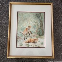 Framed watercolour painting showing the full artwork with foxes and background nature scene.