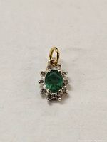 front view of pendant showing oval emerald and surrounding diamonds