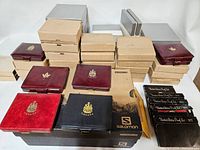 Assortment of closed presentation cases and outer cardboard boxes stacked together