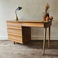 Front view of desk showing ripple-front drawers and tapered legs