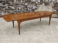 Full front view of walnut coffee table showing overall form and tapered legs