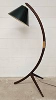 Full view of curved teak arc floor lamp with black conical shade