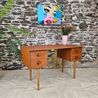 Front view showing desk profile, two drawer banks, round knobs and tapered legs