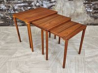 Three teak nesting tables arranged nested from largest to smallest
