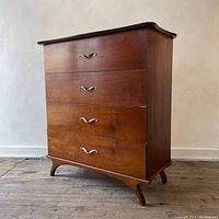 Front view of four-drawer walnut dresser showing overall shape, finish and handle placement