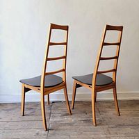 Three-quarter view of both chairs showing ladder-back design and black seats