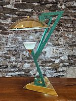 Front view of lamp showing green frame, brass base and dome shade