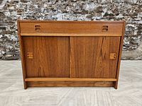 Front view of teak record cabinet showing drawer and sliding doors