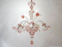 Full view of the chandelier showing five arms, central column, pink accents and gold flecks