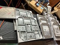 Picture frames lot on table with various sizes visible, some unopened in packaging