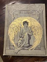 Grey cloth hardcover with gilt illustration featuring a winged figure holding a key, titled 'The Raven'.