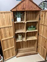Front interior view of the cabinet showing multiple wooden shelves and interior space.