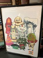 Framed white T-shirt showing multiple colorful cartoon puppet characters from Lidsville with the show's logo.