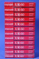 Side view of individual cassette cases stacked, showing Maxell UR 60 labeling and normal bias IEC Type I designation.