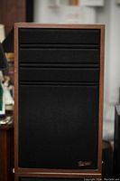 Full view of one Audio Sphere Classic II speaker with a wood frame and black grille cloth covering the drivers.