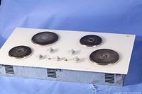 Full view of the electric cooktop showing four burners and control knobs.
