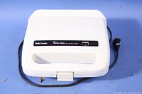 Closed white Betty Crocker mini muffin maker with visible power cord and power switch on top