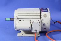 Side view of the white sealed single phase electric motor showing the mounted wiring box and orange power cable with wear spots on paint.