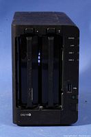 Front view of Synology DS218+ NAS device showing two installed hard drives in accessible bays with LED indicators for status, LAN, Disk 1 and Disk 2.