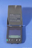 Palm Pilot IIIx device with screen and button interface, cover opened showing character input chart for the Graffiti software.