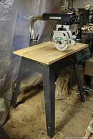 Full view of DeWalt 710 radial arm saw on steel stand showing table and saw head