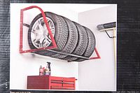 Photo showing the tire rack mounted on a wall supporting 5 tires with rims.