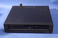 Top and front view of a black Fisher FVH-2901 VHS Video Cassette Recorder showing front loading VHS slot and control buttons.