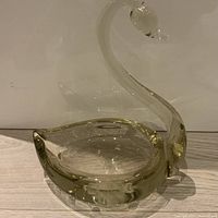 Photo of a clear Venetian glass bowl shaped like a swan showing the whole item including the curved neck and head