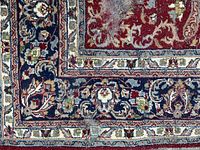 Corner close-up showing navy floral border, red field and signs of wear