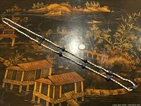 Full length view of the pearl and lapis lazuli necklace laid out with a quarter coin to show scale.