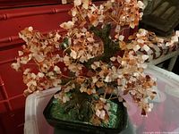 Photo of vintage articulated bonsai tree with small polished quartz and amber stones for leaves, detailed trunk, and green base in black pot.