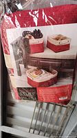 Photo of package label showing set of 3 Christmas themed fabric baskets with red and beige colors and holiday designs.