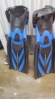 Photo of blue and black Tusa diving flippers showing blades, adjustable straps, and heel support.