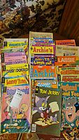 Front view of assorted vintage comic books stacked upright showing titles such as Daisy & Donald, Archie, Looney Tunes, Lassie, and Jughead