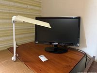 Samsung SyncMaster P2250 monitor on a wooden surface showing front view including screen, base, and cables.