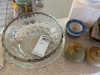 Top view of a nested pair of clear glass serving bowls showing the scalloped edges and pattern.