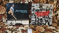 Bruce Springsteen Live 1975-85 album and Rolling Stones cassettes set on floral fabric