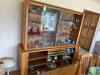 Full view of the 2-piece teak hutch with items inside