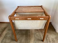 Front view of teak side table with canvas magazine sling showing full frame