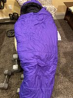 Purple MEC mummy-style sleeping bag laid flat showing general shape and condition
