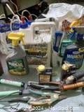 Photo of various garden chemical spray bottles and garden hand tools grouped together on a surface.