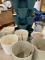 Variety of white and brown ceramic hanging and regular pots with handles