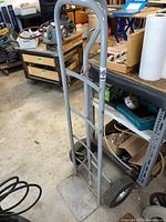 Front view of metal hand truck dolly showing tall handle and base plate
