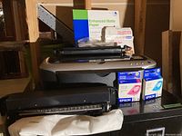 Front view of Epson Stylus Photo 2200 printer with ink cartridges, and Enhanced Matte Photo Paper pack in background.