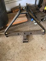 Photo of a black metal three point hitch frame with some dirt and wear.