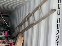 View of the entire ladder inside a storage container showing the ladder length and condition.