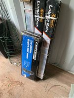 Boxed Craftex 6-shelf lumber racks and Certified tire shelves leaning against a wall on a wooden floor.