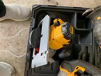 Circular saw and jig saw inside open black Dewalt carrying case